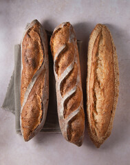 Fresh French baguettes on the table with linen tablecloth. Top view.