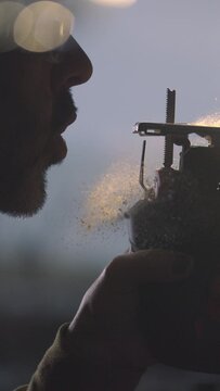 Experience the timeless ritual of a craftsman as he gently blows sawdust from his saw in slow motion. Our vertical 4K footage offers a glimpse into the meticulous care and dedication of woodworking cr