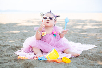 Baby girl playing in the sand on the beach,Baby playing on the sandy beach near the sea 