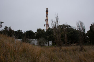 un faro en la playa un dia nublado