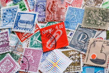 Ukraine, Kiyiv - January 12, 2023 Clip on norwegian postage stamp.Postage stamps.A collection of world stamps in a pile.Postage stamps from different countries and times