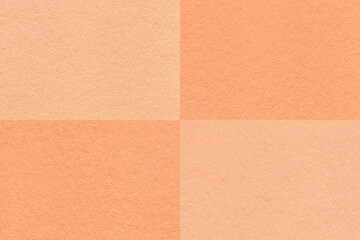 Texture of craft peach fuzz and coral paper background with cells pattern, macro. Vintage kraft cardboard
