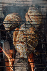 Fresh gourami fish is grilled over a burning and smoky fire