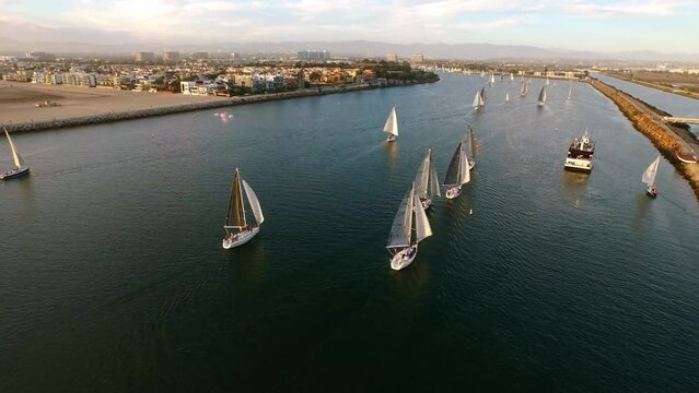 Aerial Forward Shot Of Nautical Vessels In Sea By Residential Town Under Cloudy Sky - Marina del Rey, California