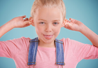 Child, portrait and tongue out in studio for goofy, silly and playful facial expression with blue...