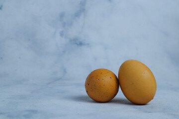 two chicken eggs on a blue background