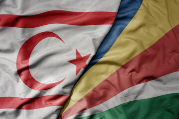 big waving national colorful flag of seychelles and national flag of northern cyprus.
