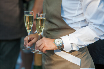 A moment of celebration is captured in this close-up with two hands holding flutes of sparkling...