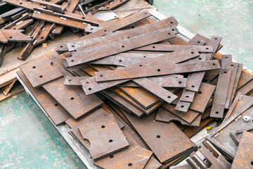 Stack of steel plates cut to different shapes.