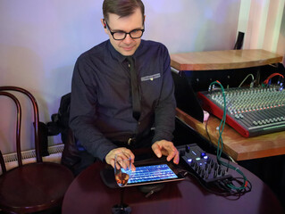 One man is sitting with a tablet and mixing audio
