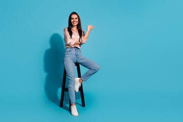 Full length photo of cool positive woman wear silky blouse sitting stool thumb empty space isolated...