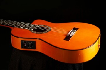 Classical Spanish flamenco guitar close up, dramatically lit isolated on black background with copy...