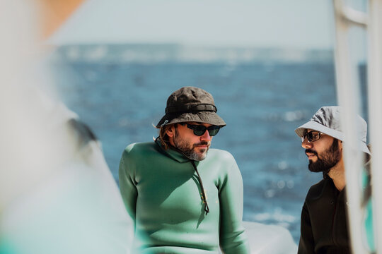 Two men having a conversation by the sea - Powered by Adobe