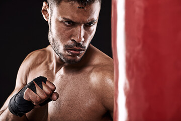 Boxing, man or serious in studio with punching bag for training, exercise or competition fight with...