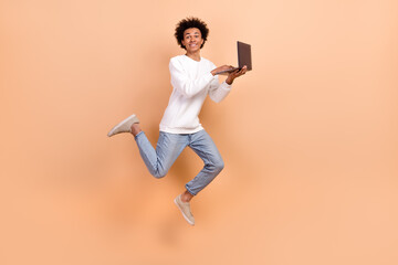 Full length photo of cheerful positive man it specialist software developer hold netbook device isolated on beige color background