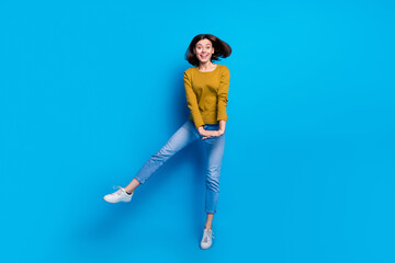Full length photo of sweet adorable woman wear shirt dancing jumping high empty space isolated blue...