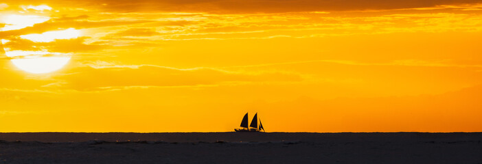 sailboat with a maui sunset in the background