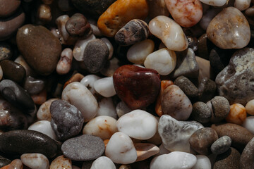 Sea stones of different colors on the shore in close-up
