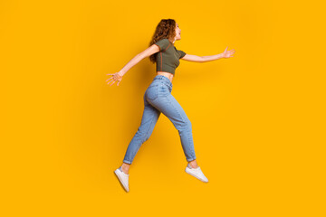 Fototapeta na wymiar Photo of cheerful excited cute girl stylish clothes running fast hurrying seasonal sale hot offer isolated on yellow color background
