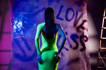 Rear behind studio portrait of slender pretty model girl hand touch herself love kiss banner multicolor neon background