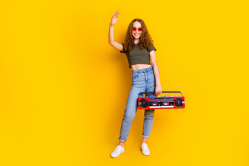 Photo of cheerful glad girl wear trendy clothes have fun listen boombox melody rhythm chill isolated on vivid yellow color background