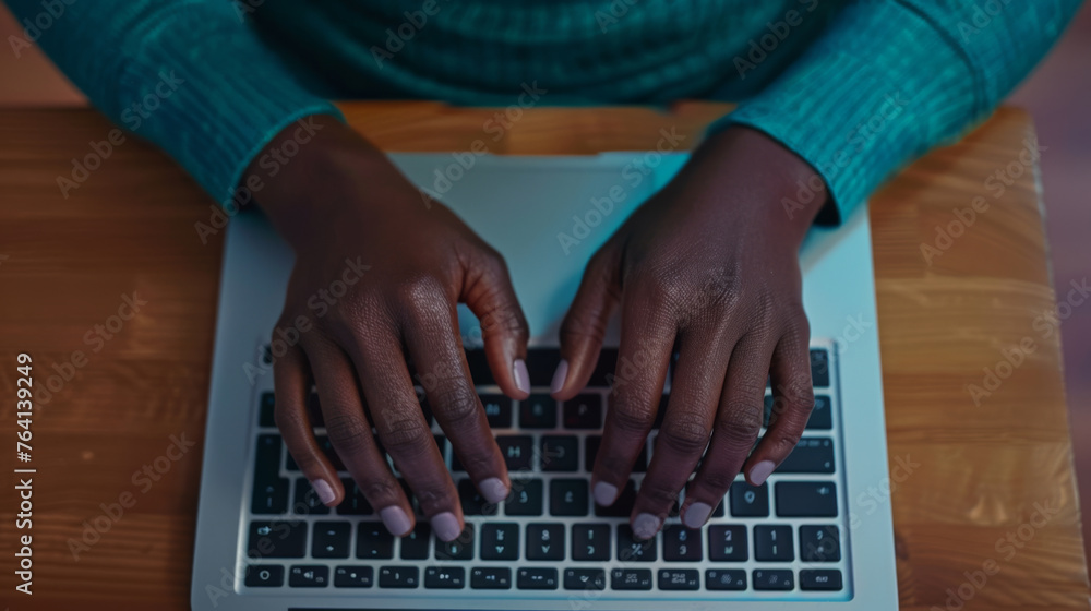 Poster close-up of hands typing on a backlit laptop keyboard in a dimly lit setting.