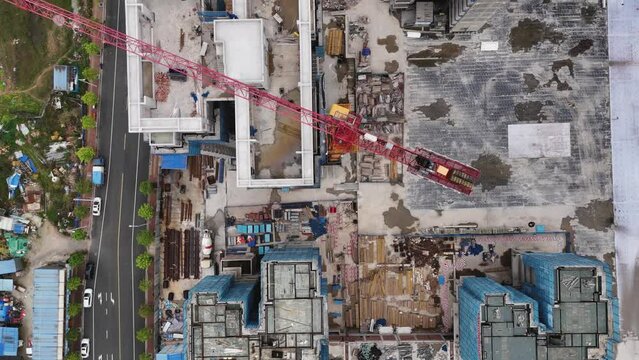Builders on the roof of a new residential building. Bird's eye view. construction crane, 4k, developer, multi-storey residential construction, China