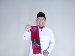 Moslem Asian man smiling at the camera and showing one fingers sign