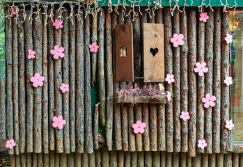 Decorative wall with wooden poles open window and pink flowers outdoors in countryside - 764140836