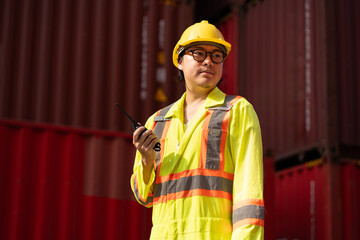Asia logistic engineer man worker or foreman working with walkie talkie at container site	 - 764160676