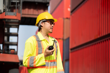 Asia logistic engineer man worker or foreman working with walkie talkie at container site	 - 764160691