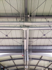 The metal pipe row of the electric system along the ceiling.