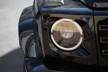Headlights and front wheel of a modern car close-up, auto design.