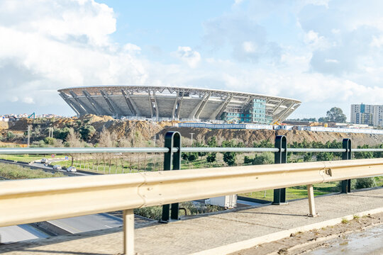 Algiers, Algeria- January 22, 2023: Douera stadium of MCA Algerian soccer club under construction vue from the freeway on cheraga road. Cloudy blue sky, clear sunny day, trees and plants in dried soil