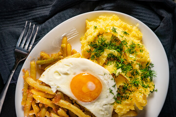 Fried eggs with boiled potatoes and yellow string beans.