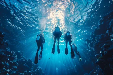 Foto op Canvas A group of scuba divers with fins are seen swimming through a beautiful coral reef in clear blue ocean waters, showcasing undersea exploration © svastix