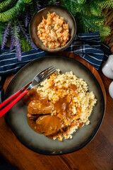 Braised pork neck in own sauce served with barley groats and salad.