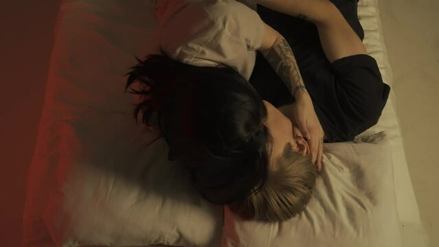 Top view young loving couple romantic time in bedroom. Man and woman half naked sensual lovers laying in bed together, passion, intimacy kissing, foreplay and bonding.