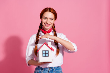 Photo of adorable lovely girl realtor wear trendy clothes hold miniature house dream own new flat isolated on pink color background