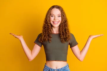 Foto op Canvas Photo of lovely cute girl wear stylish khaki clothes two arms presents empty space variants vs scales isolated on yellow color background © deagreez