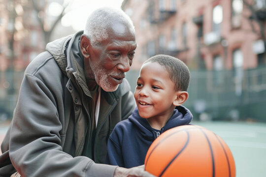 A young boy and an older man are playing with a basketball