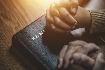 christian and prayer Group of christians holding hands praying together to believe and bible on wooden table for prayer meeting. - obrazy, fototapety, plakaty