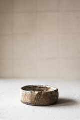 An old clay bowl on a beige background. Japanese style. Wabi-sabi.