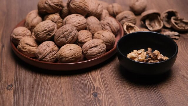 Noci sgusciate nella ciotola, noci nel piatto e sulla tavola, gusci sulla tavola