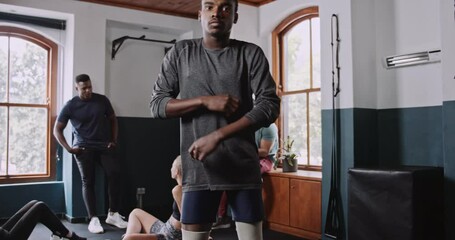 Disabled African American athlete poses for photograph with arms folded in fitness studio  - Powered by Adobe