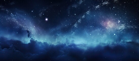 An atmospheric image of a sky filled with stars and clouds in shades of blue and black