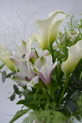 A beautiful, festive bouquet, composition of white calla lilies, purple white orchids, flowers, green leaves, branches.