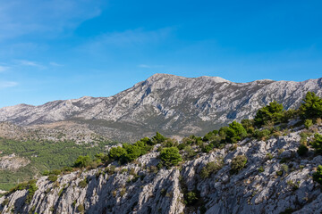 Fototapeta na wymiar Idyllic hiking trail to medieval fortress Starigrad in Omis, Split-Dalmatia, Croatia, Europe. Panoramic view of mountain peak Sveti Jure in Dinara mountains, Dinaric Alps in the Balkans. Wanderlust