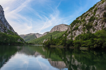 Cetina river merging with Adriatic Sea in coastal town Omis, Split-Dalmatia, Croatia, Europe. Idyllic gorge surrounded by steep Dinara mountains. Majestic coastline of Omis Riviera. Balkan summer