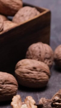 Video verticale, ravvicinato di noci intere e sgusciate con gusci sul tavolo